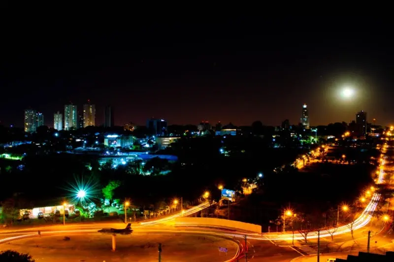 A school bus in motion on a busy road with a view of the city skyline.