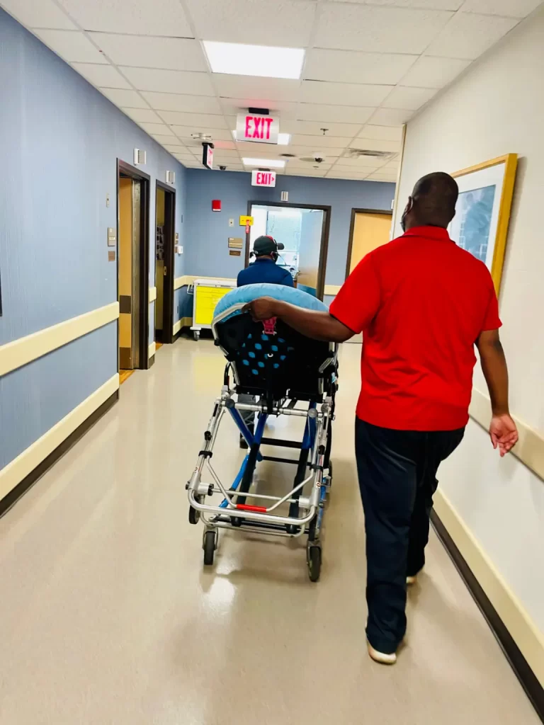 A healthcare professional assisting a patient with medical stretcher transportation.